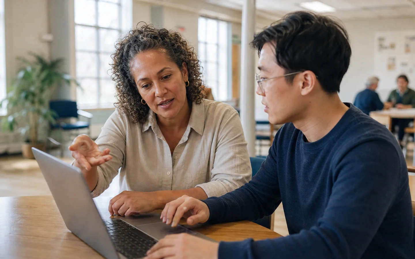 Nonprofit director and analyst reviewing the metrics behind a decision