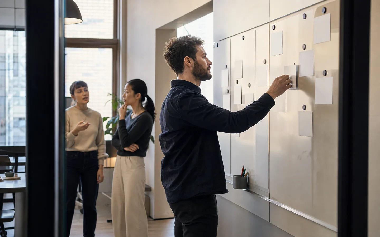 Líder de ventas actualizando un tablero de oportunidades con su equipo